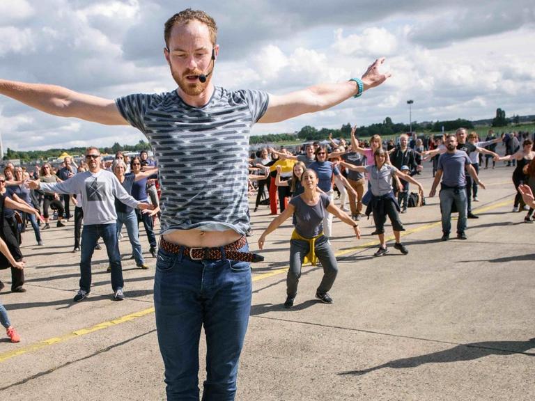 Der Tänzer und Choreograf, Boris Charmatz, Besuchern des "Fous de danse - Ganz Berlin tanzt auf Tempelhof" der Volksbühne auf dem Tempelhofer Feld. 