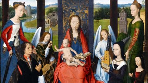 Öl-Gemälde mit Maria in einem roten langen Gewand und dem nackten Jesuskind auf ihrem Schoß im Mittelpunkt. Zwei höfische Damen begrenzen links und rechts das Bild, am vorderen Rand kniet links ein Herrund rechts eine Dame in schwarz. Die Engel links und rechts halten jeweils ein Streich- und ein kleines Tasteninstrument.