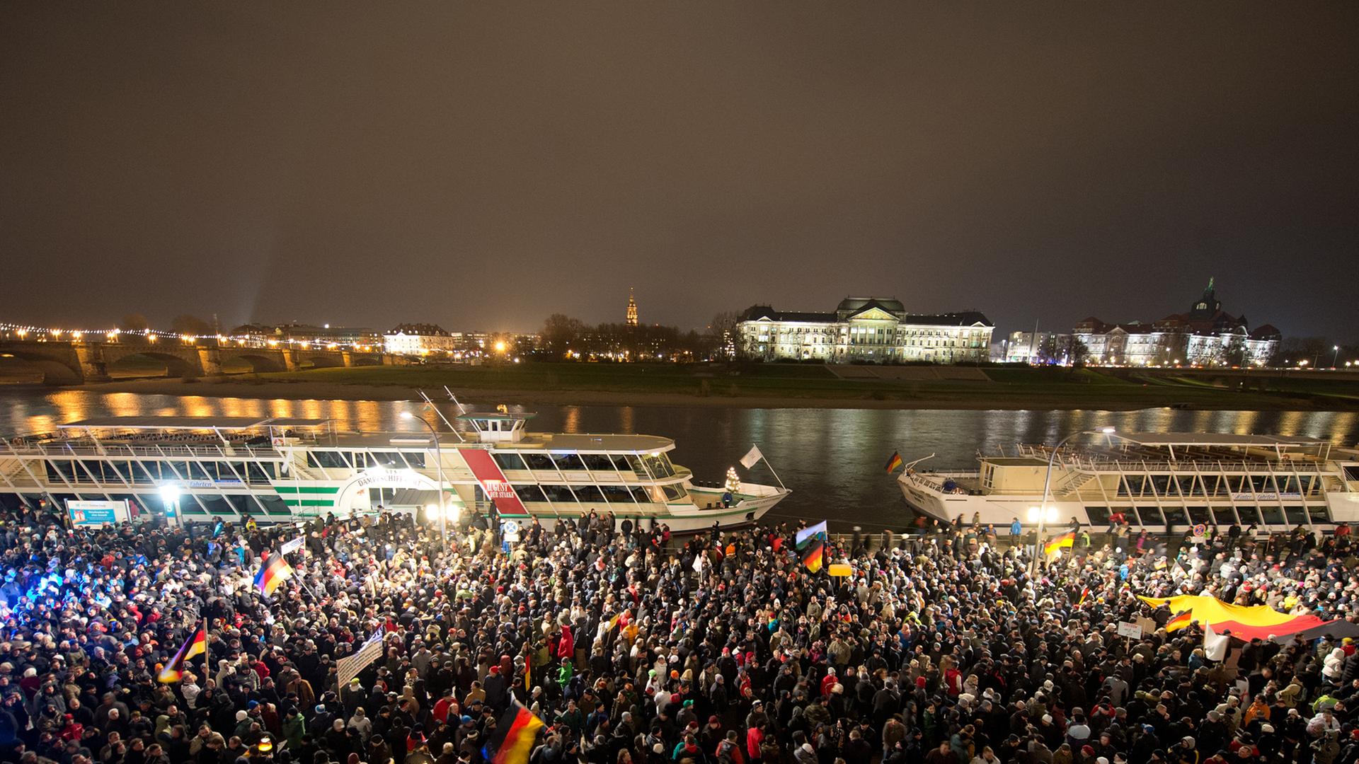 Teilnehmer einer Demonstration unter dem Motto "Patriotische Europäer gegen die Islamisierung des Abendlandes" (PEGIDA) warten am 01.12.2014 auf dem Terrassenufer in Dresden (Sachsen). Sie wollten zum Theaterplatz marschieren, wurden daran aber von Gegendemonstranten gehindert.
