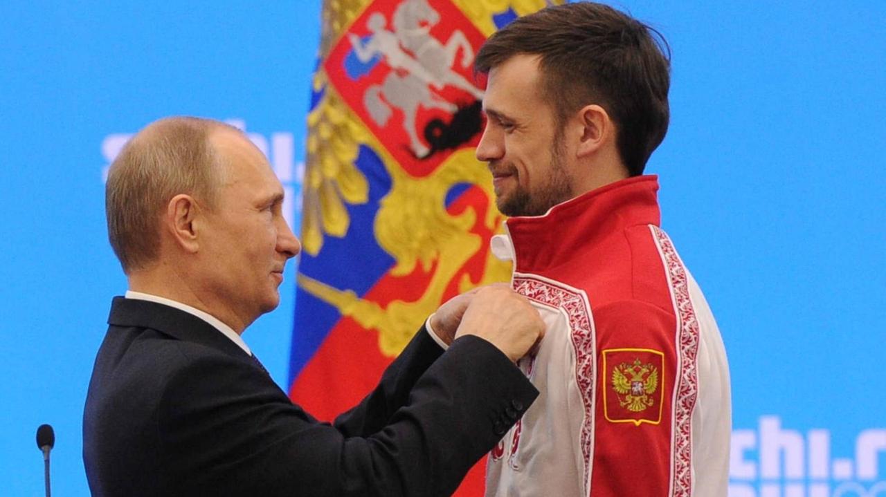 Der russische Präsident Putin gratuliert dem Skeleton-Olympiasieger der Winterspiele in Sotschi, Alexander Tretjakow. 