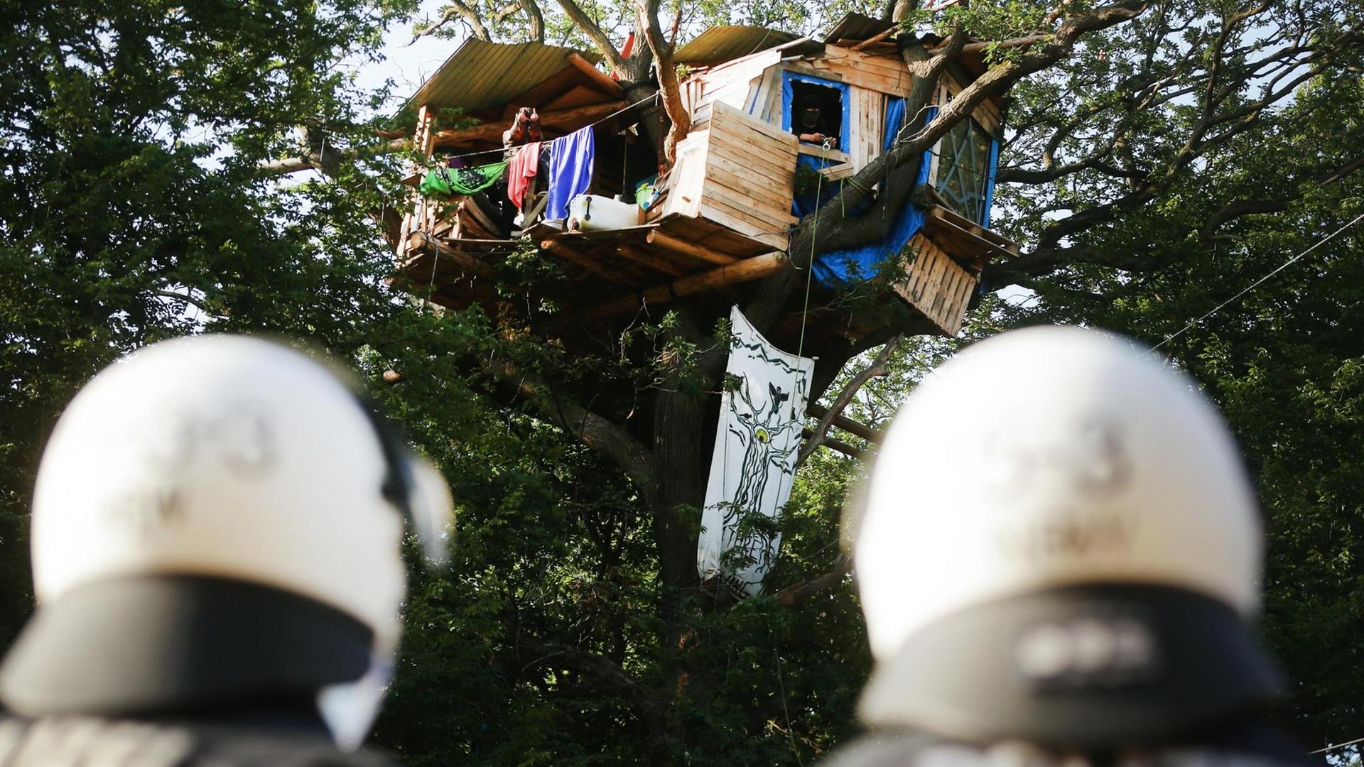 Polizisten stehen im Hambacher Forst am Fuße eines Baumes, in dem Klima-Aktivisten ein Baumhaus gebaut haben, 2020.