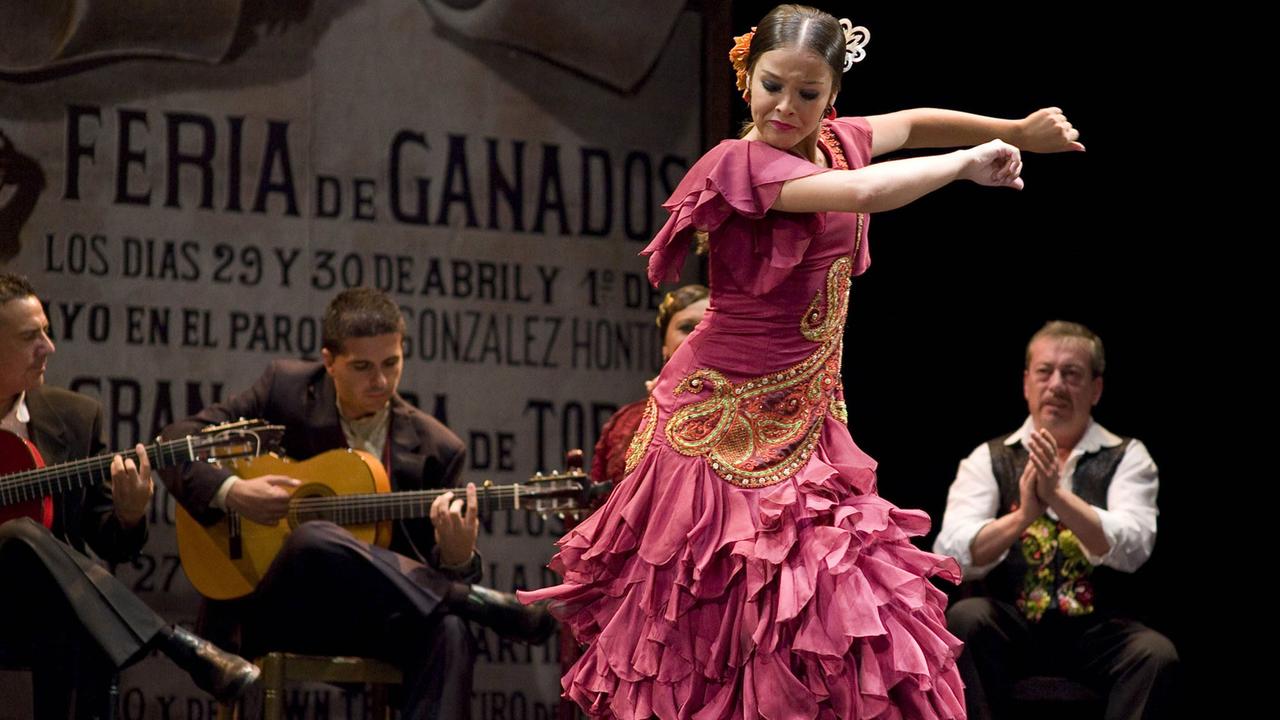 Eine Flamencotänzerin auf einem Festival - im Hintergrund spielen Musiker. Das Show ist in Madrid.