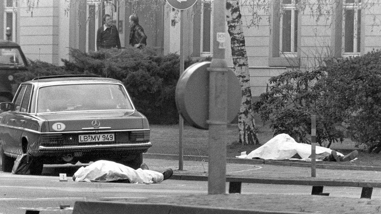 Der Tatort mit den zugedeckten Leichen von Siegfried Buback (rechts hinten) und seines Fahrers (links) sowie der Dienstwagen des Generalbundesanwaltes in Karlsruhe 