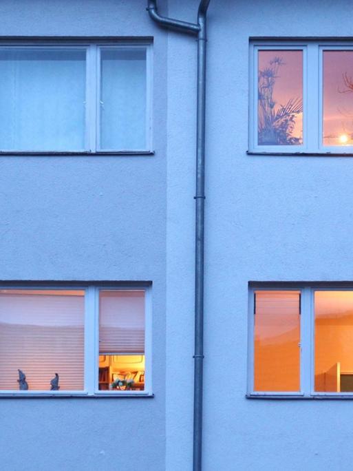 Berlin. In einem Mehrfamilienhaus im Bezirk Steglitz-Zehlendorf sind in der Abenddämmerung bereits einige Fenster erleuchtet.