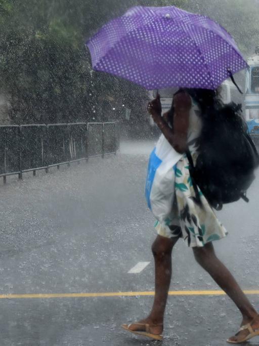 Eine Frau geht in Colombo, Sri Lanka, durch den Regen
