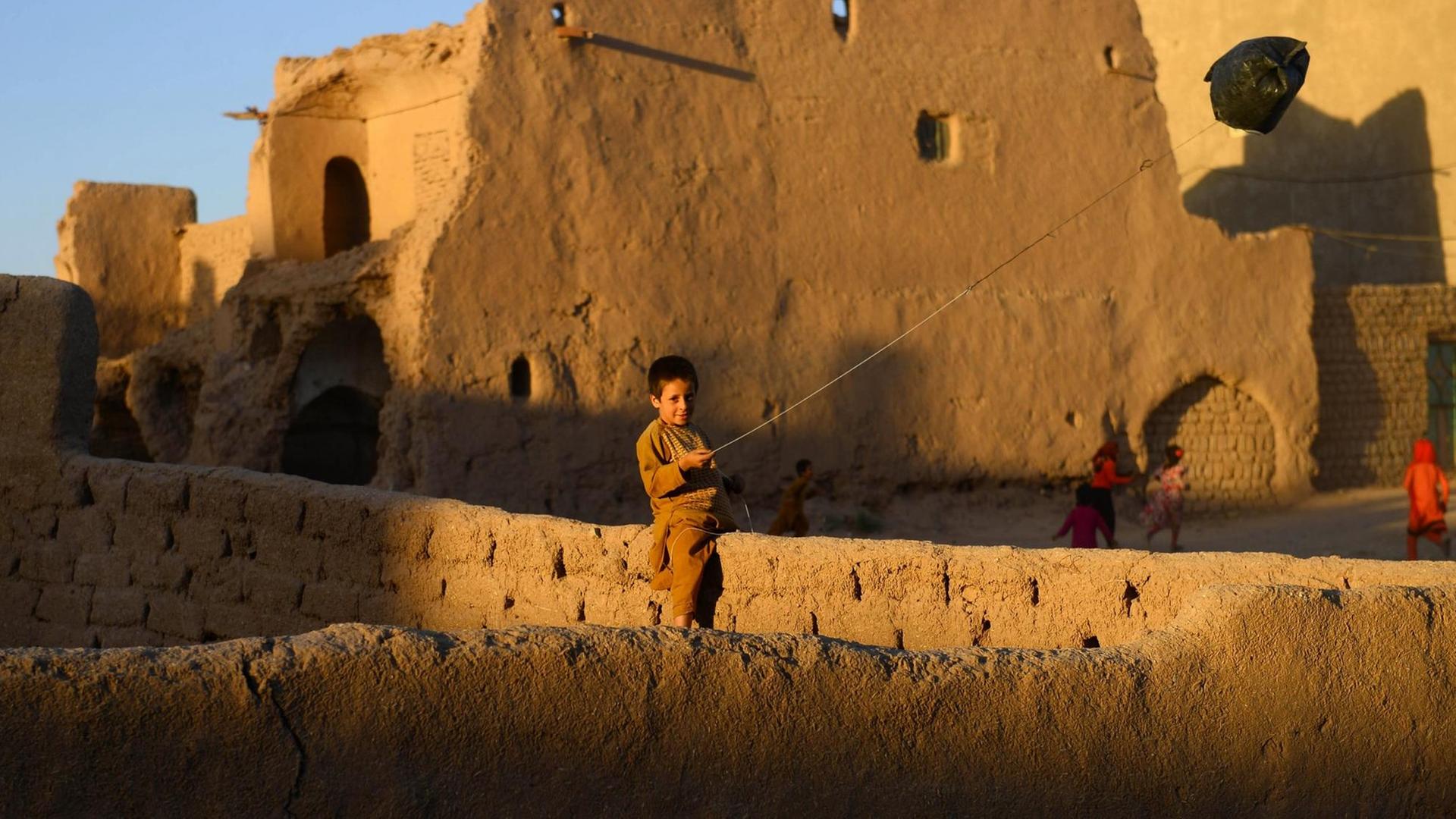 Ein Junge spielt mit einem Drachen aus einer Plastiktüte in der afghanischen Stadt Herat