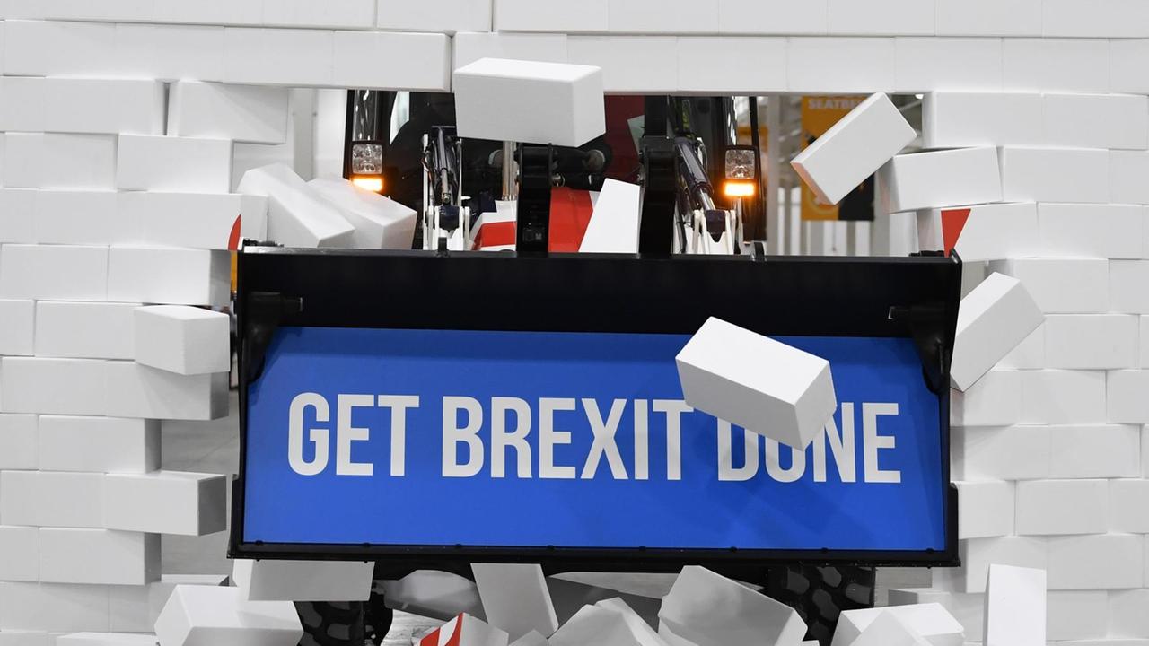 "Get Brexit Done" steht auf einem Schild, das durch eine Styropormauer gefahren wird "Get Brexit Done" steht auf einem Schild, das durch eine Styropormauer gefahren wird
