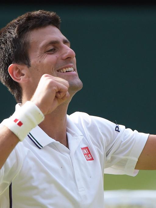 Der Serbe Novak Djokovic nach seinem Sieg. Er lacht und reißt die Arme nach oben.