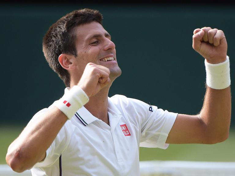 Der Serbe Novak Djokovic nach seinem Sieg. Er lacht und reißt die Arme nach oben.