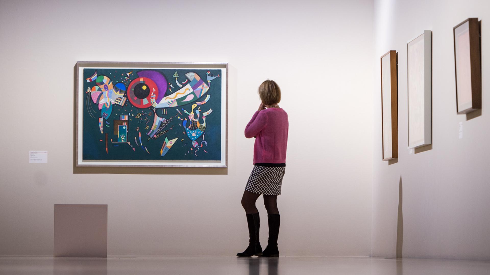 Oktober 2015: Eine Frau betrachtet in der Ausstellung "Klee & Kandinsky" im Kunstbau der Städtischen Galerie im Lenbachhaus in München das Kunstwerk "Autour du cercle" von Wassily Kandinsky von 1940 Oktober 2015: Eine Frau betrachtet in der Ausstellung "Klee & Kandinsky" im Kunstbau der Städtischen Galerie im Lenbachhaus in München das Kunstwerk "Autour du cercle" von Wassily Kandinsky von 1940