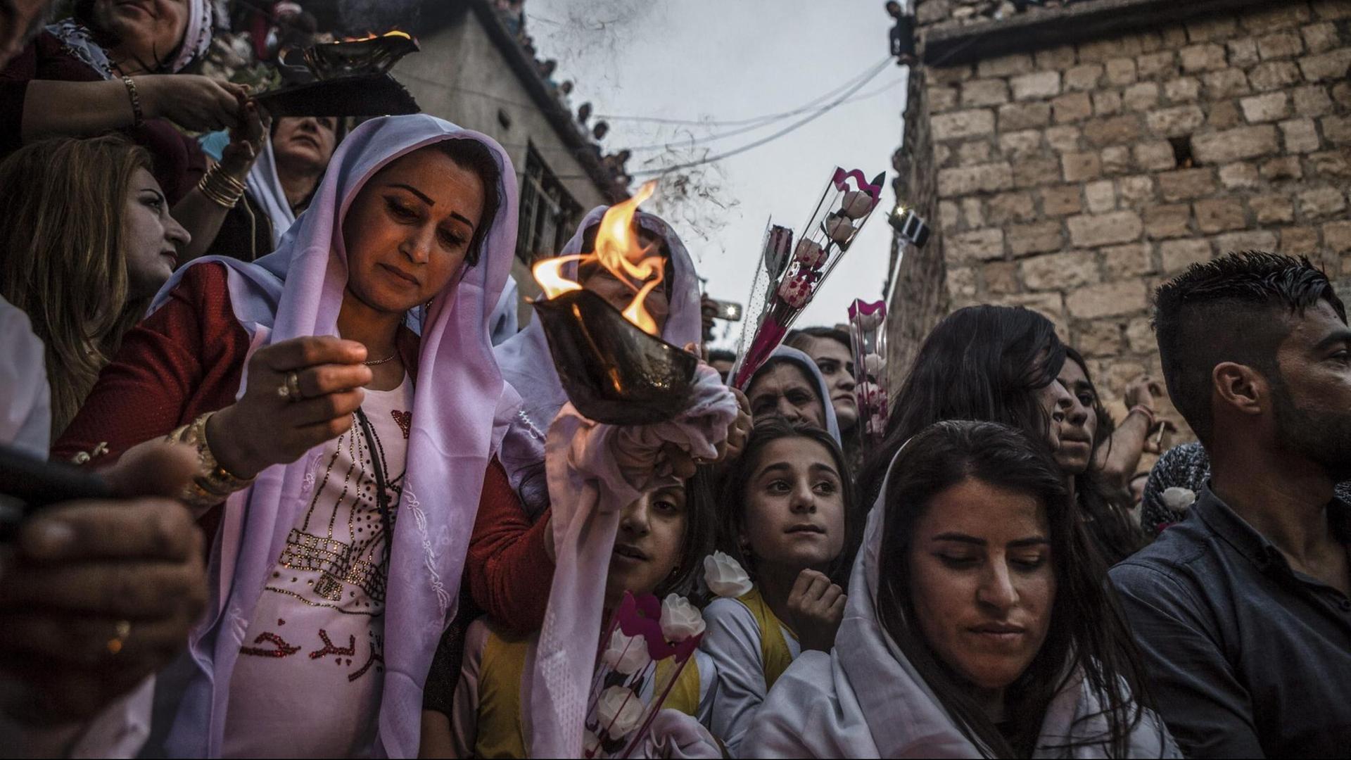 Jesiden im Irak feiern das Neujahrsfest und zünden Kerzen an.