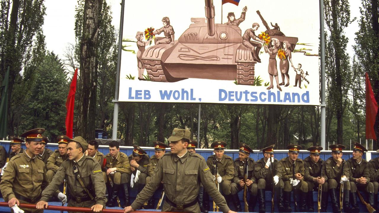 Russische Soldaten vor einem Banner mit der Aufschrift "Leb wohl, Deutschland" beim Abzug der russischen Armee aus Deutschland 1994