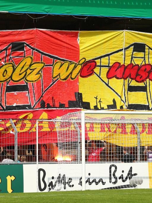 Choreografie der Wilhelmshavener Fans in der Heimkurve. Sie halten ein großes, buntes Banner mit der Aufschrift: "Stolz wie unsere Fußballtradition" hoch.