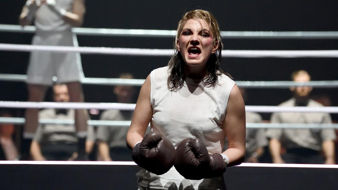 Josephine Köhler mit Boxhandschuhen in kämpferischer Pose vor einem Boxring.