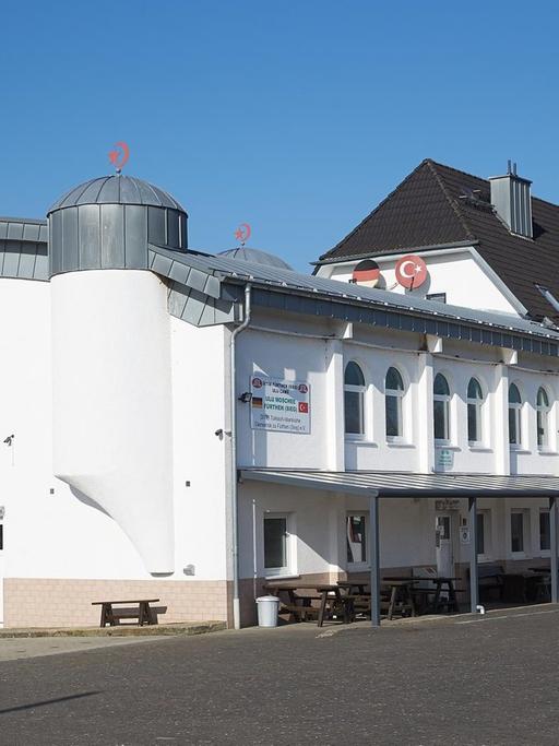 Das Bild zeigt das weiße Gebäude vor blauem Himmel.