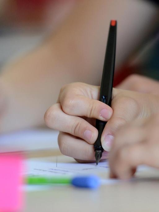 Schüler der Neckar-Realschule schreiben am 08.07.2013 in Nürtingen (Baden-Württemberg) während des Unterrichts. Foto: Franziska Kraufmann/dpa | Verwendung weltweit