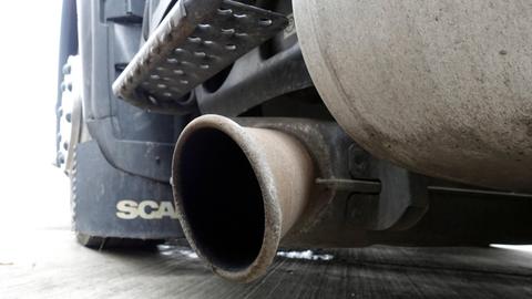 Naher Blick auf Höhe des Straßenbelags auf einen Auspuff