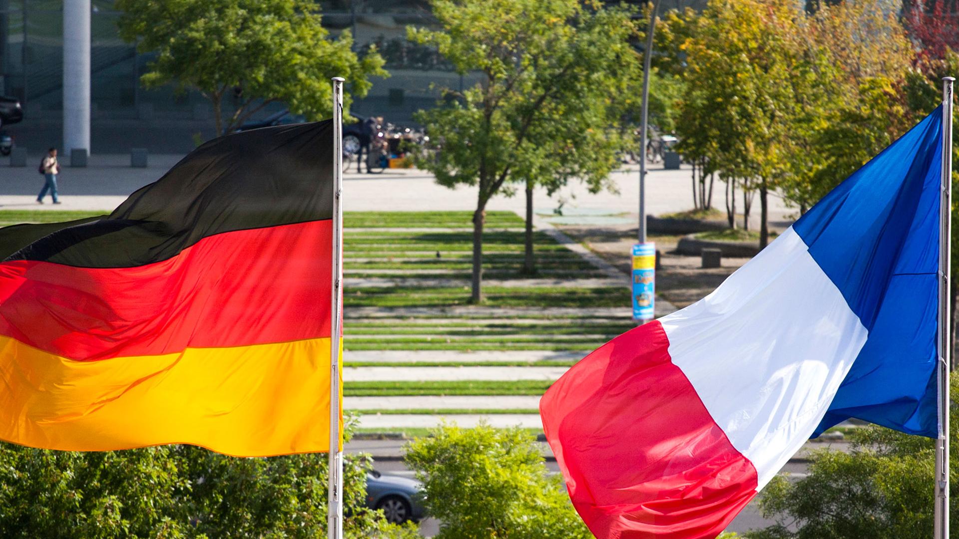 Die deutsche und die französische Nationalflagge wehen aus Anlass des Besuches von Frankreichs Regierungschef Manuel Valls vor dem Bundeskanzleramt in Berlin am 22.09.14.