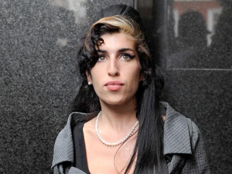 Amy Winehouse vor eine Marmorwand