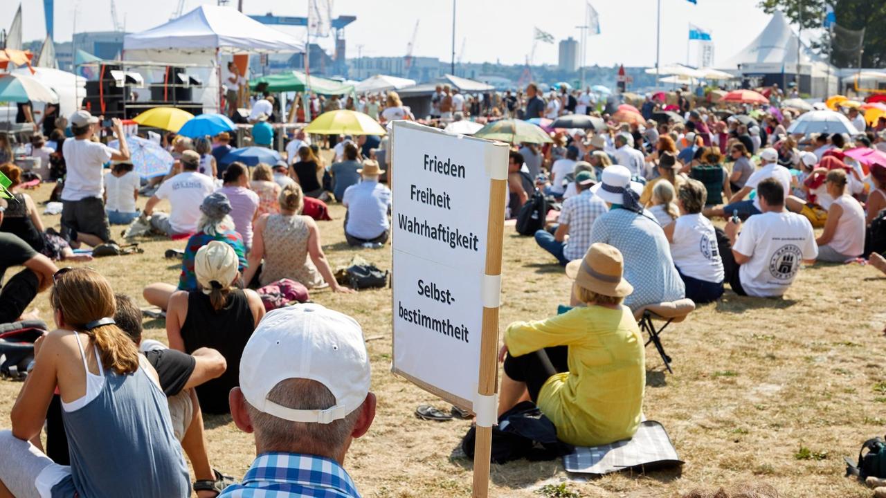 Ein Teilnehmer der Demonstration hält ein Transparent mit der Aufschrift "Frieden Freiheit Wahrhaftigkeit Selbstbestimmung".