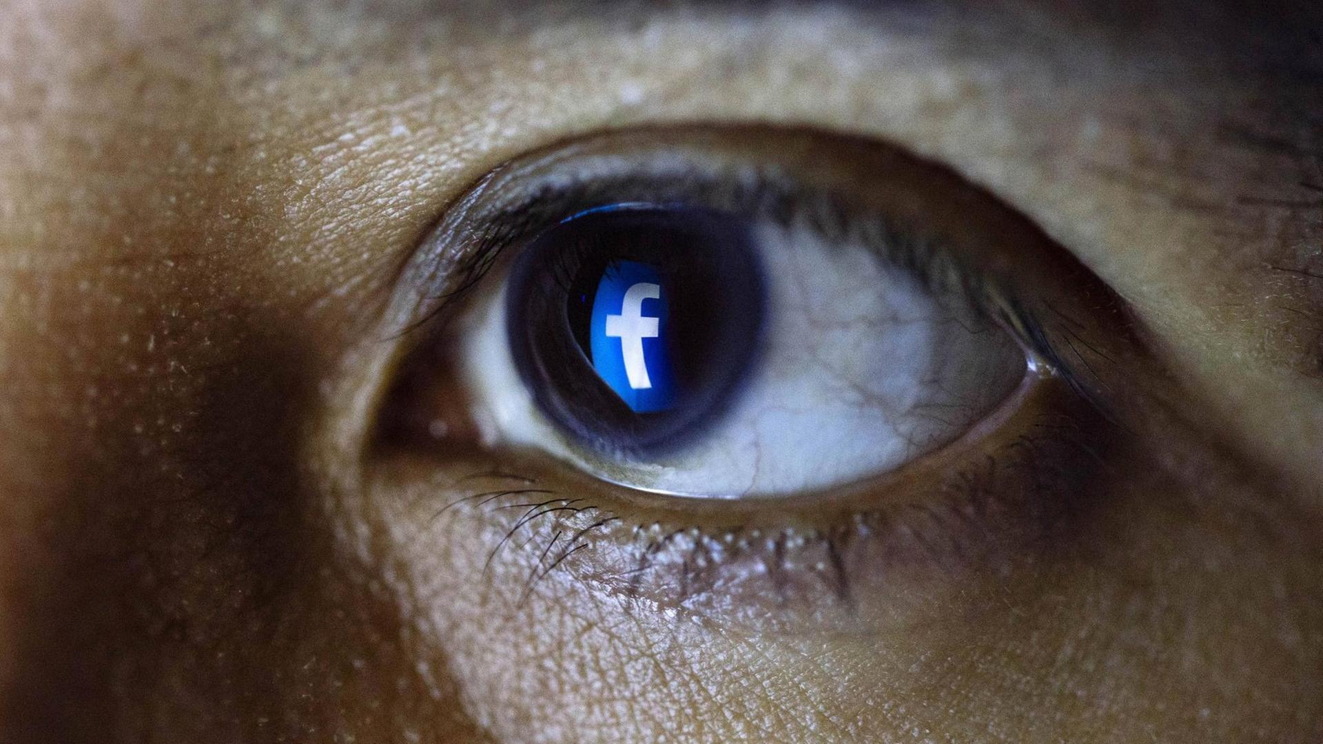 Ein Facebook-Logo spiegelt sich in einem Auge