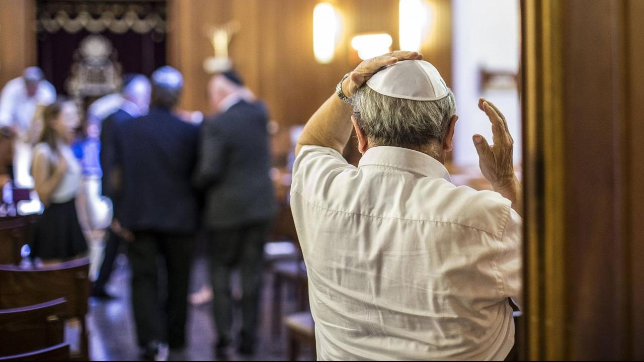 Ein Mann richtet seine Kippa, als er die Synagoge in Wiesbaden betritt