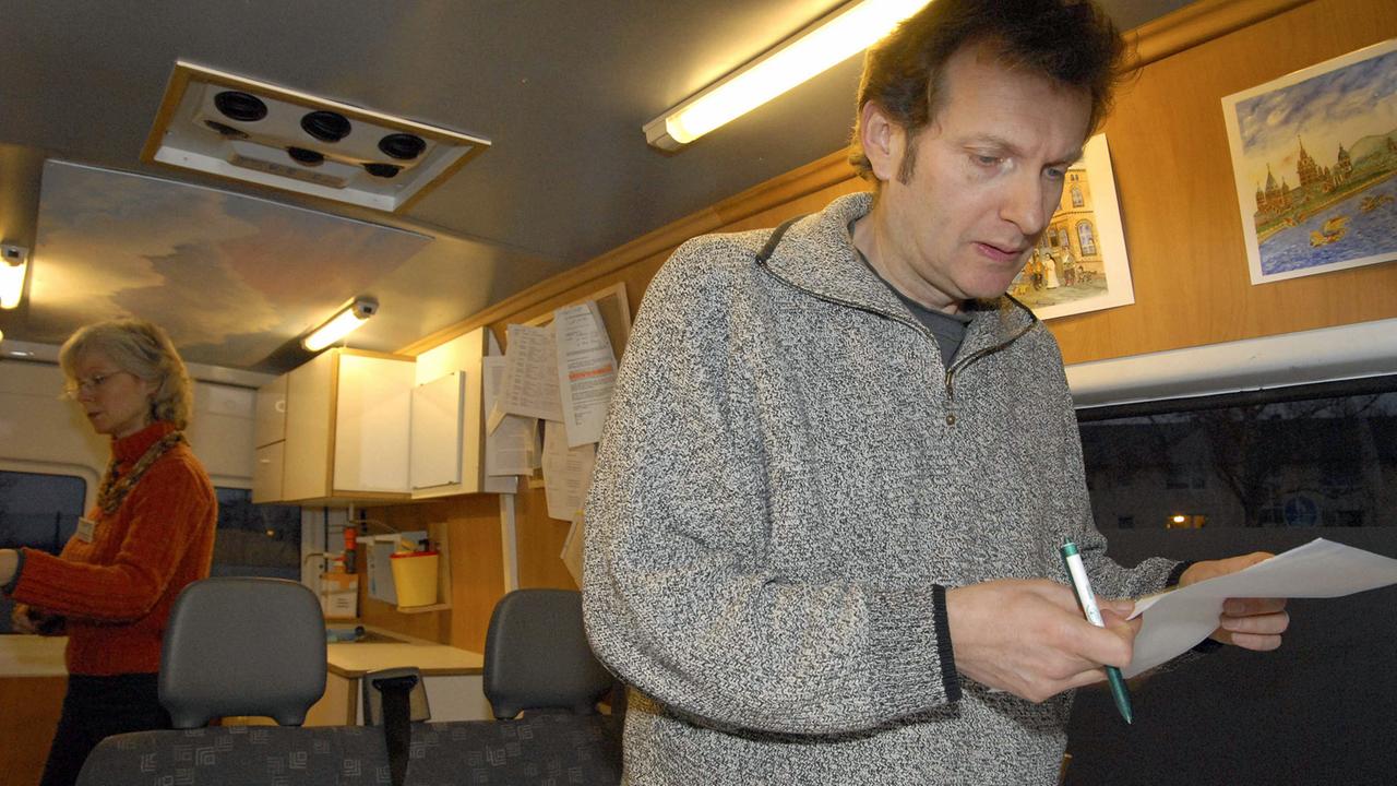 Der Arzt Gerhard Trabert (r.) behandelt in einem Arztmobil in Mainz Obdachlose.