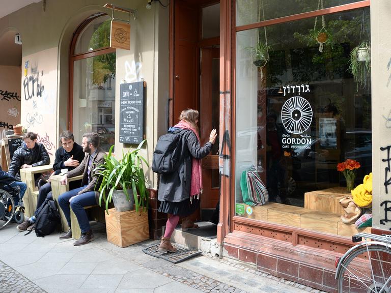 Gäste sitzen am 03.05.2017 vor dem Cafe und Recordstore "Gordon" mit israelischer Küche in der Allerstraße in Berlin Neukölln. Hier werden auch Schallplatten und Vinyl angeboten.
