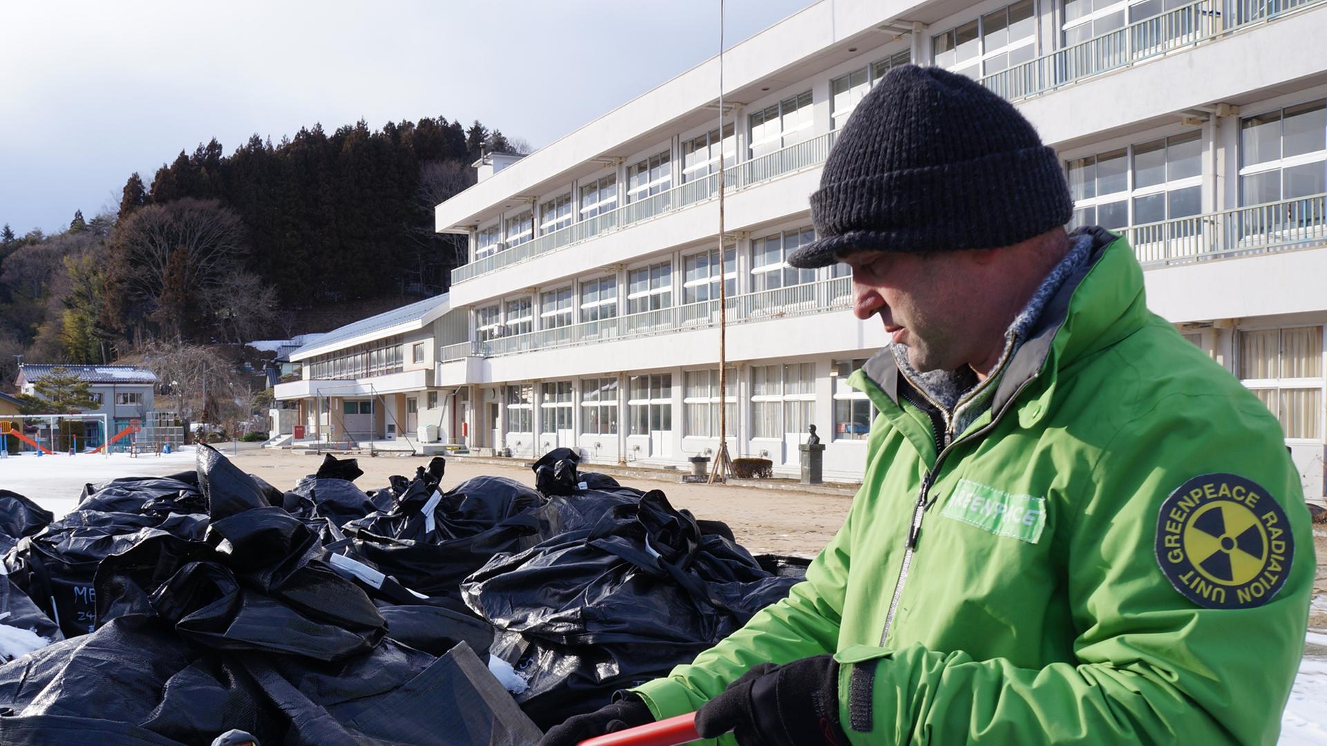 Der Greenpeace-Aktivist Smital mit Säcken radioaktiven Abfalls in Fukushima