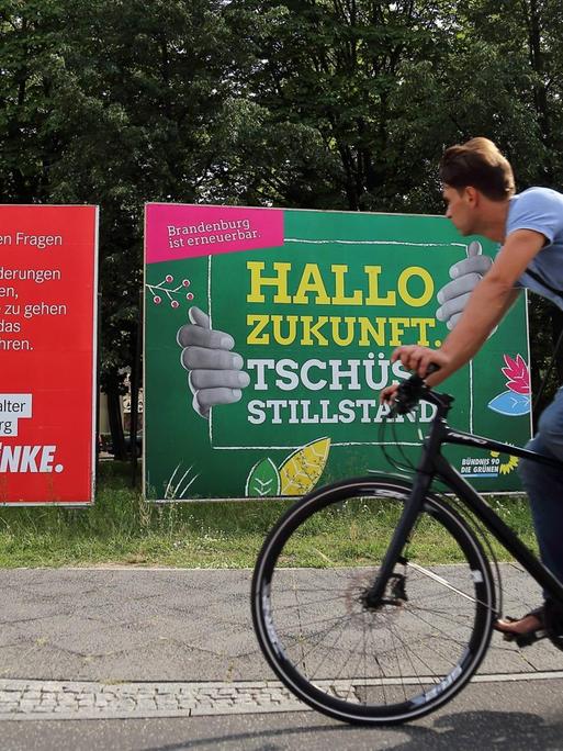 Fahrradfahrer fährt vor Wahlplakate von Die Linke, Bündnis 90/Die Grünen und CDU für die Landtagswahl in Brandenburg vorbei