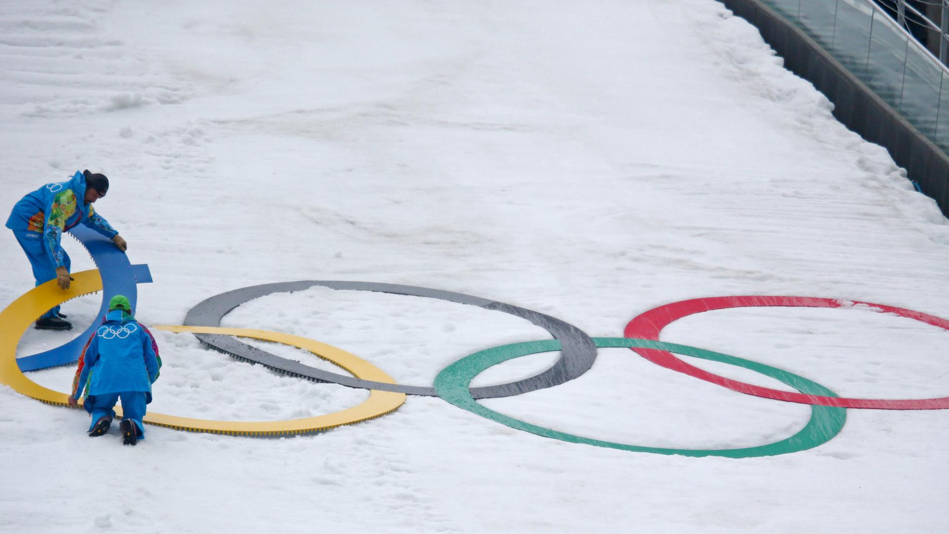 Olympische Ringe werden auf einer Piste in Sotschi prepariert.