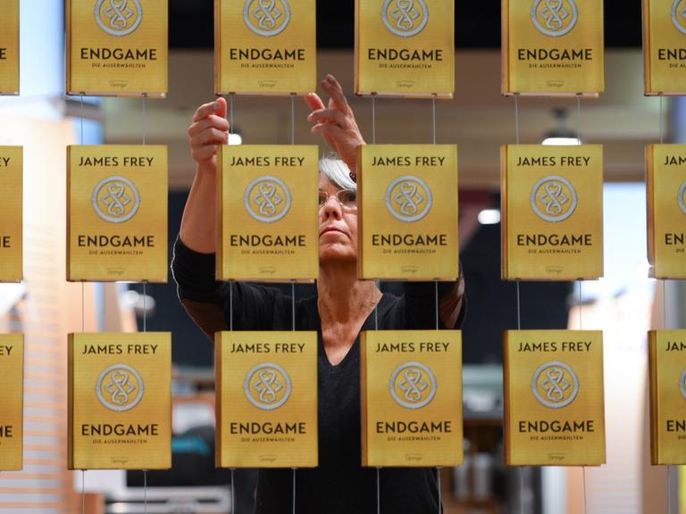 Claudia Maas richtet auf der Buchmesse in Frankfurt am Main (Hessen) am Stand der Verlagsgruppe Oetinger Exemplare von James Freys Buch "Endgame" aus.