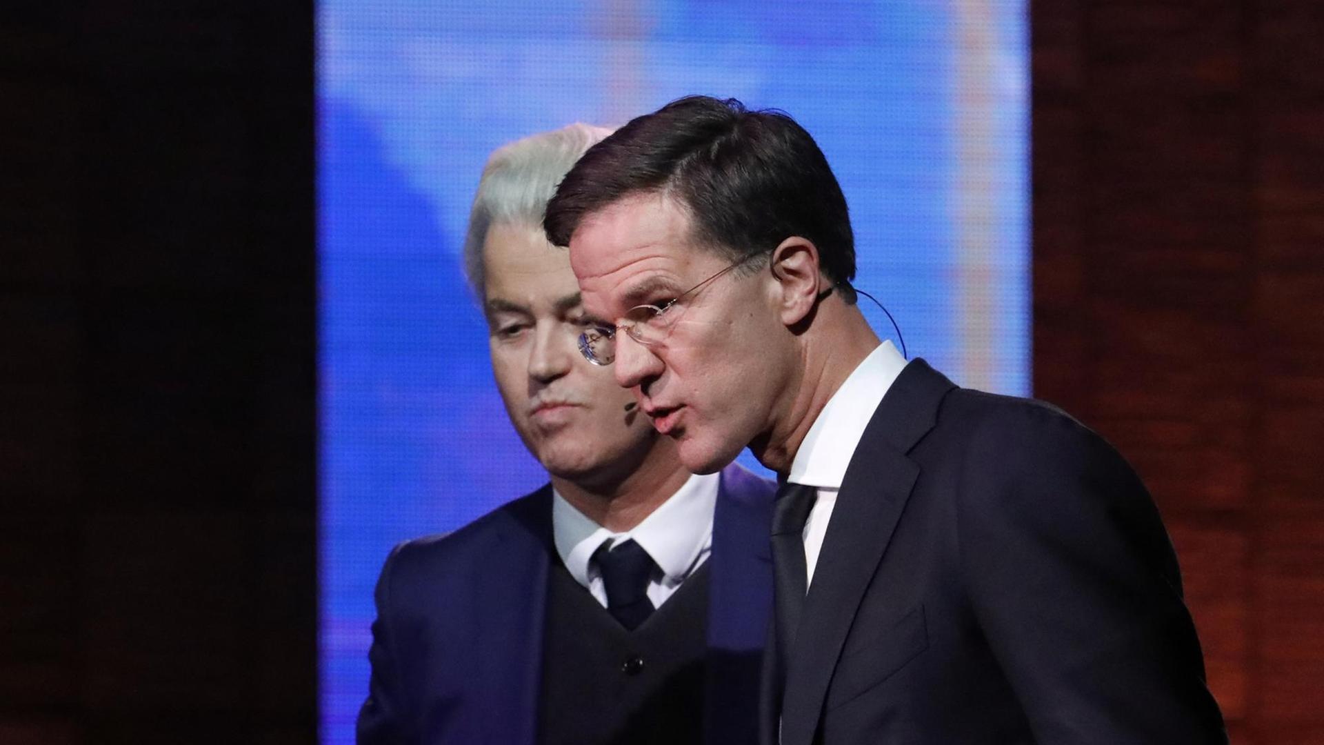 Der rechtsliberale Ministerpräsident Mark Rutte (r) und der Rechtspopulist Geert Wilders stellen sichwährend einer TV-Debatte den Fragen von Journalisten.