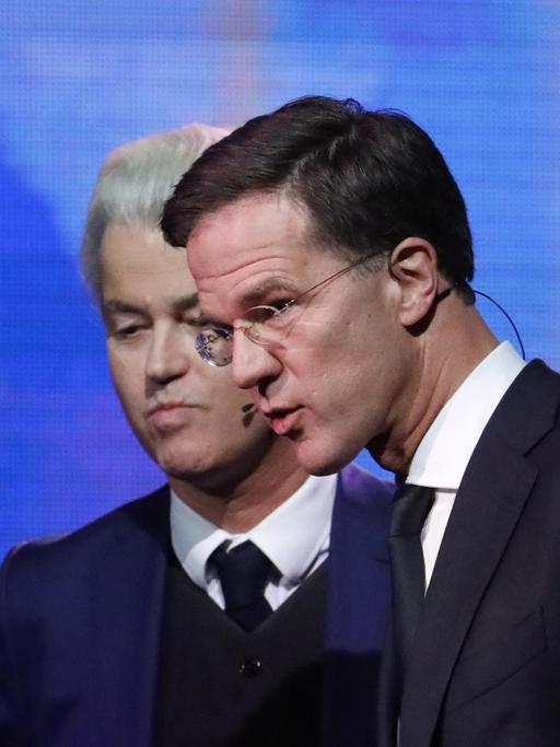 Der rechtsliberale Ministerpräsident Mark Rutte (r) und der Rechtspopulist Geert Wilders stellen sichwährend einer TV-Debatte den Fragen von Journalisten.