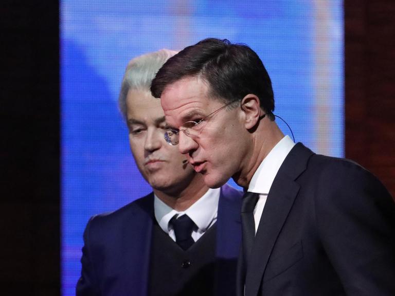 Der rechtsliberale Ministerpräsident Mark Rutte (r) und der Rechtspopulist Geert Wilders stellen sichwährend einer TV-Debatte den Fragen von Journalisten.