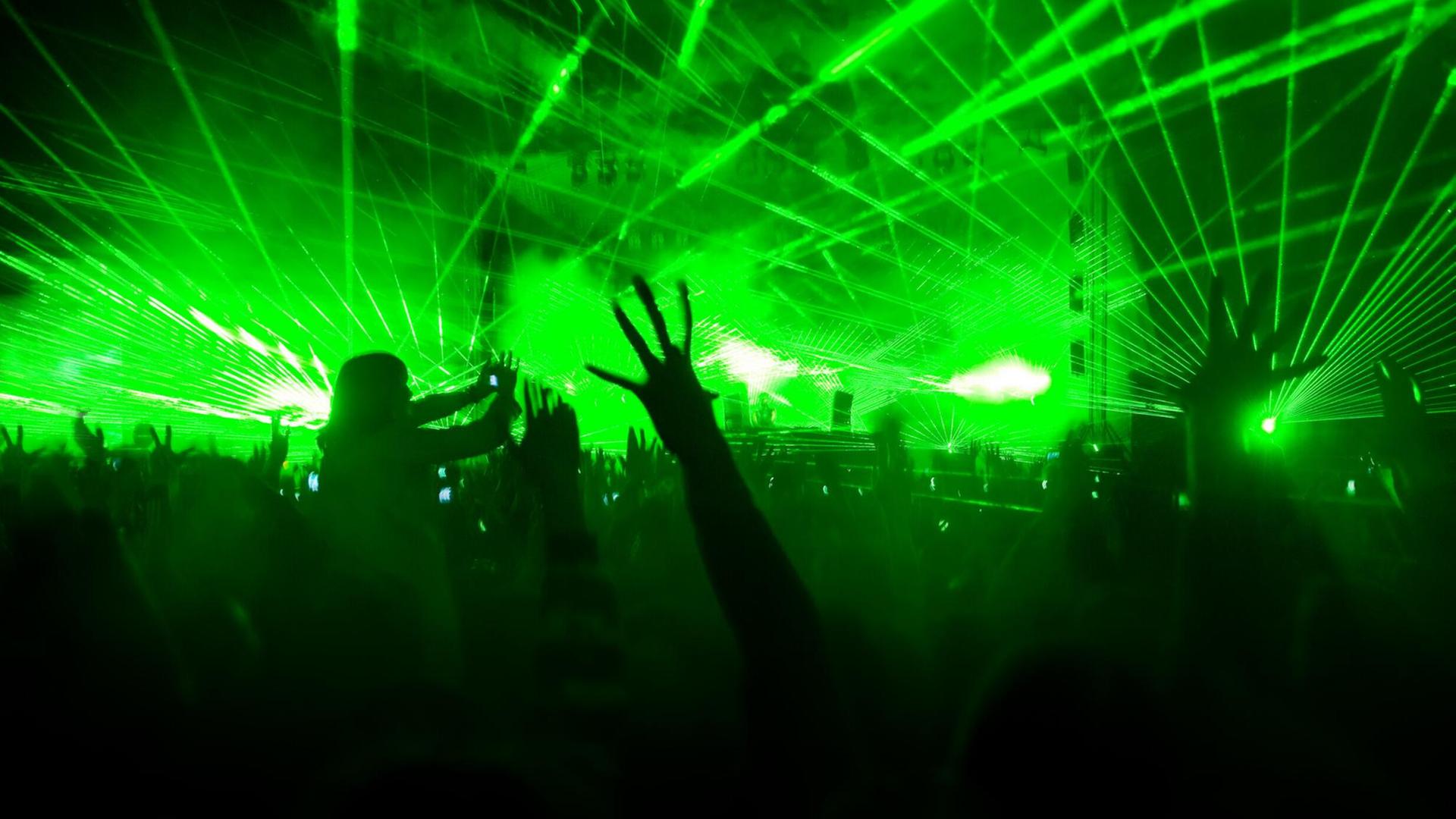 Eine Lasershow hüllt eine Konzerthalle in grünes Licht.