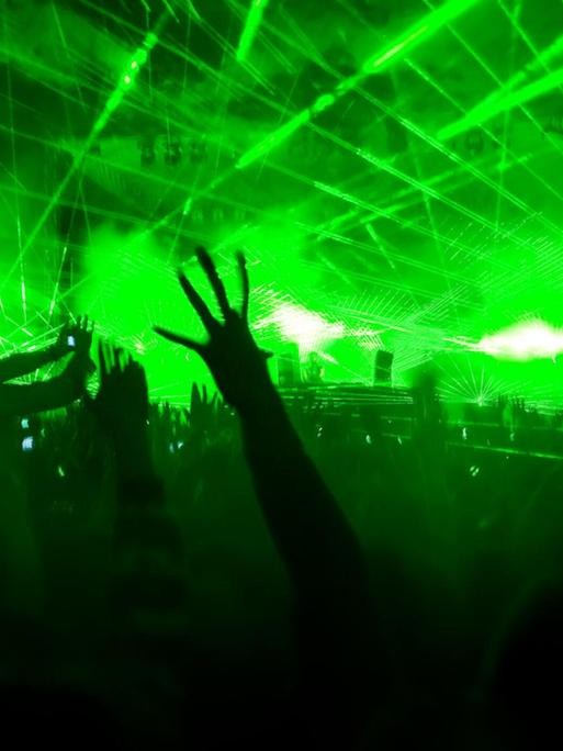 Eine Lasershow hüllt eine Konzerthalle in grünes Licht.