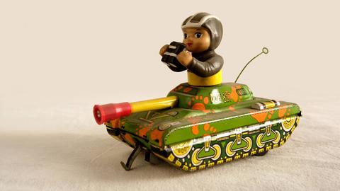Eine Spielzeugfigur in einem Miniaturpanzer.