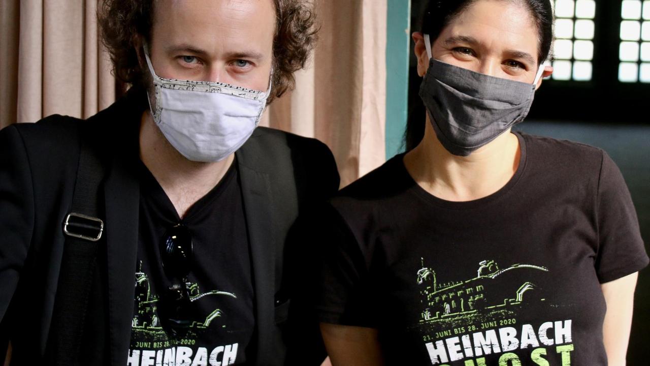 Mann und Frau mit Mundschutz tragen T-Shirts mit dem Aufdruck "Heimbach Ghost".