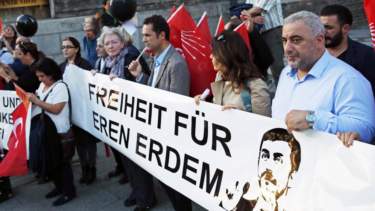 Kritiker der Türkischen Regierung demonstrieren im September 2018 in Berlin für die Freilassung des Journalisten Eren Erdem. Vor sich tragen sie ein Transparent mit der Aufschrift "Freiheit für Eren Erdem" und einem Bild von ihm.