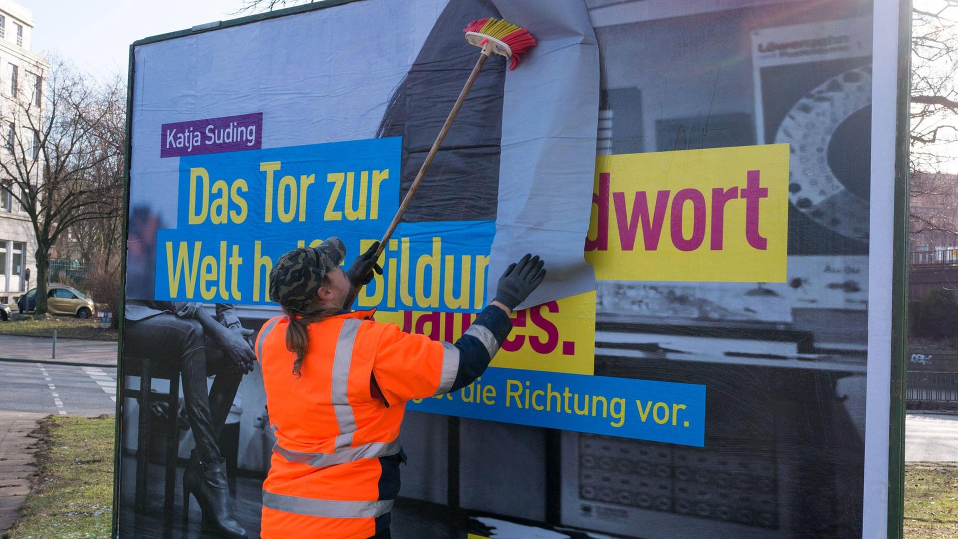 Ein Wahlplakat von Katja Suding (Freie Demokraten, FDP) für die Bürgerschaftswahlen in Hamburg am 15. Februar 2015 wird an einer Straße geklebt.