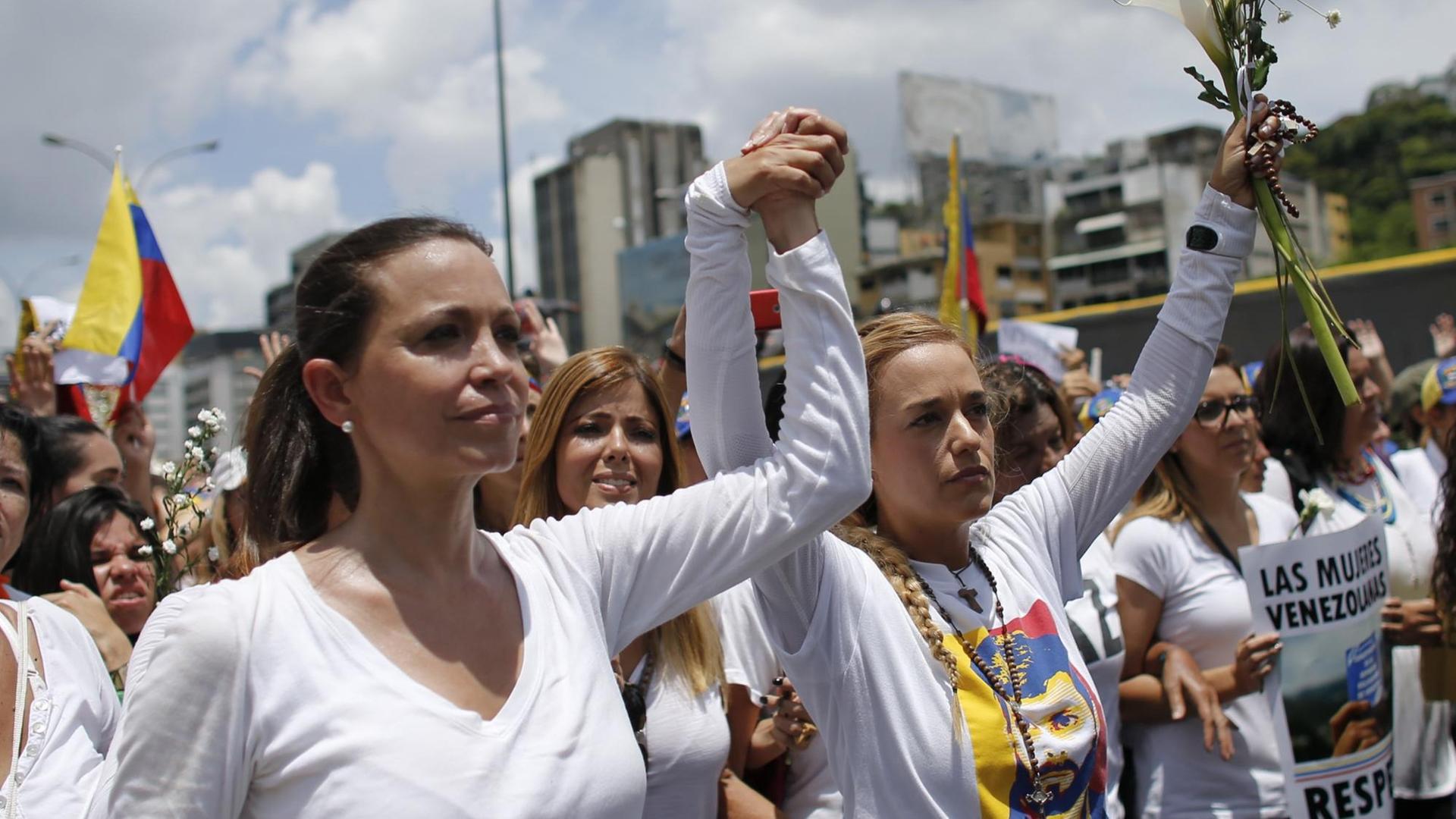 Oppositionsführerin Maria Corina Machado (l) und die Ehefrau des venezolanischen Oppositionsführers Leopoldo López, Lilian Tintori (r), nehmen am 06.05.2017 in Caracas (Venezuela) an einem Protestmarsch von Frauen gegen die Unterdrückung durch die Regierung teil. Seit Wochen fordern Demonstranten in teils gewalttätigen Protesten den Rücktritt von Staatspräsident Maduro. Foto: Ariana Cubillos/AP/dpa +++(c) dpa - Bildfunk+++
