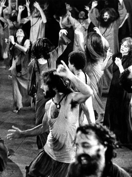 Anhänger aus aller Welt des indischen Gurus und Sektenführers Bhagwan Shree Rajneesh tanzen 1981 während der abendlichen Meditationsstunde im Ashram in Poona in Indien.