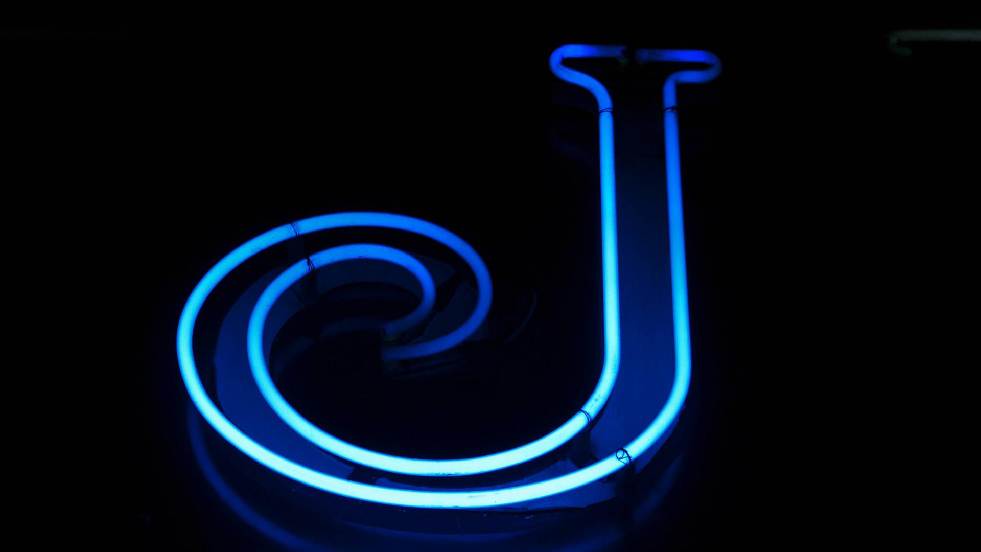 Blaue Leuchtreklame mit dem Buchstaben J