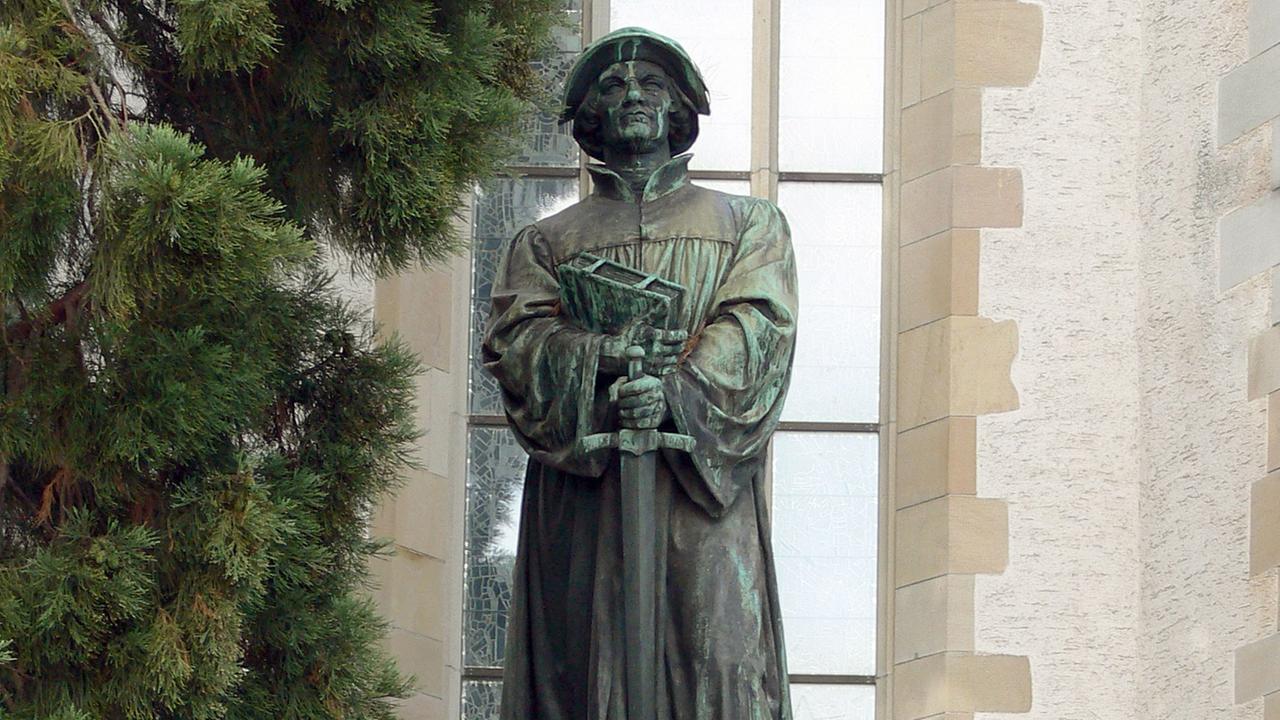 Ein Standbild des Reformators Ulrich Zwingli vor der Wasserkirche in Zürich