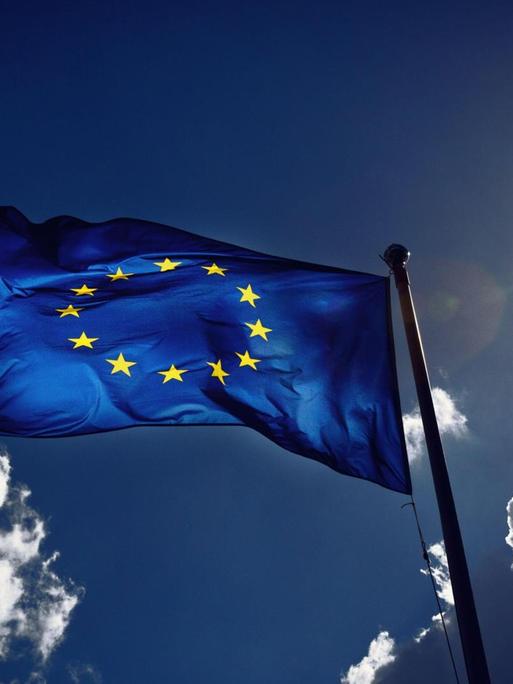 Die Fahne der Europäischen Union weht im Wind und wird von der Sonne angestrahlt. Gewitterwolken ziehen vorbei. Die Fahne der Europäischen Union weht im Wind und wird von der Sonne angestrahlt. Gewitterwolken ziehen vorbei.