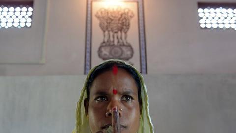 Eine Frau in Indien posiert nach der Stimmabgabe für ein Foto in einem Wahllokal in Indien.