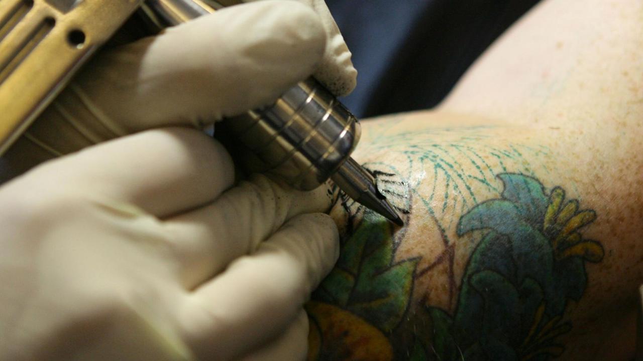 Ein Mann lässt sich ein Tattoo stechen.