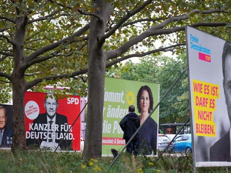Wahlplakate der Union mit Armin Laschet, der SPD mit Olaf Scholz, von Bündnis 90/Die Grünen mit Annalena Baerbock und der FDP mit Christian Lindner stehen einen Tag nach der Bundestagswahl in einer Reihe.