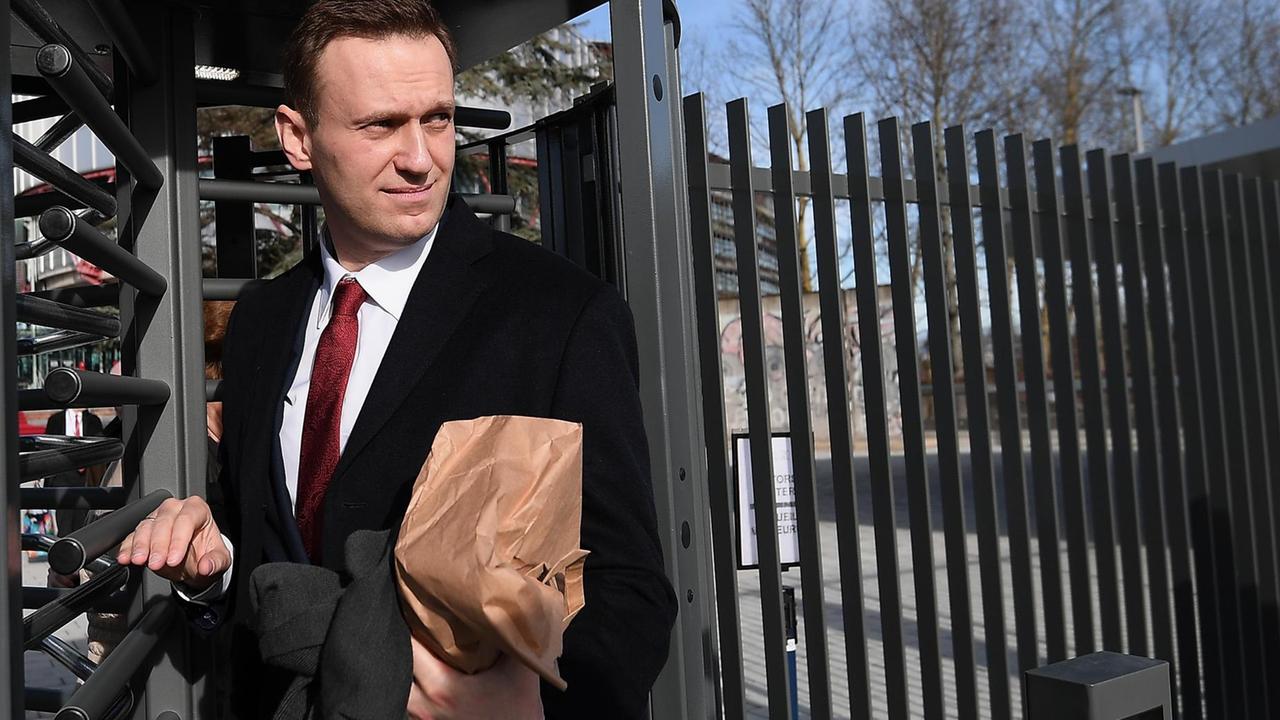 Navalny geht durch ein Drehgitter.